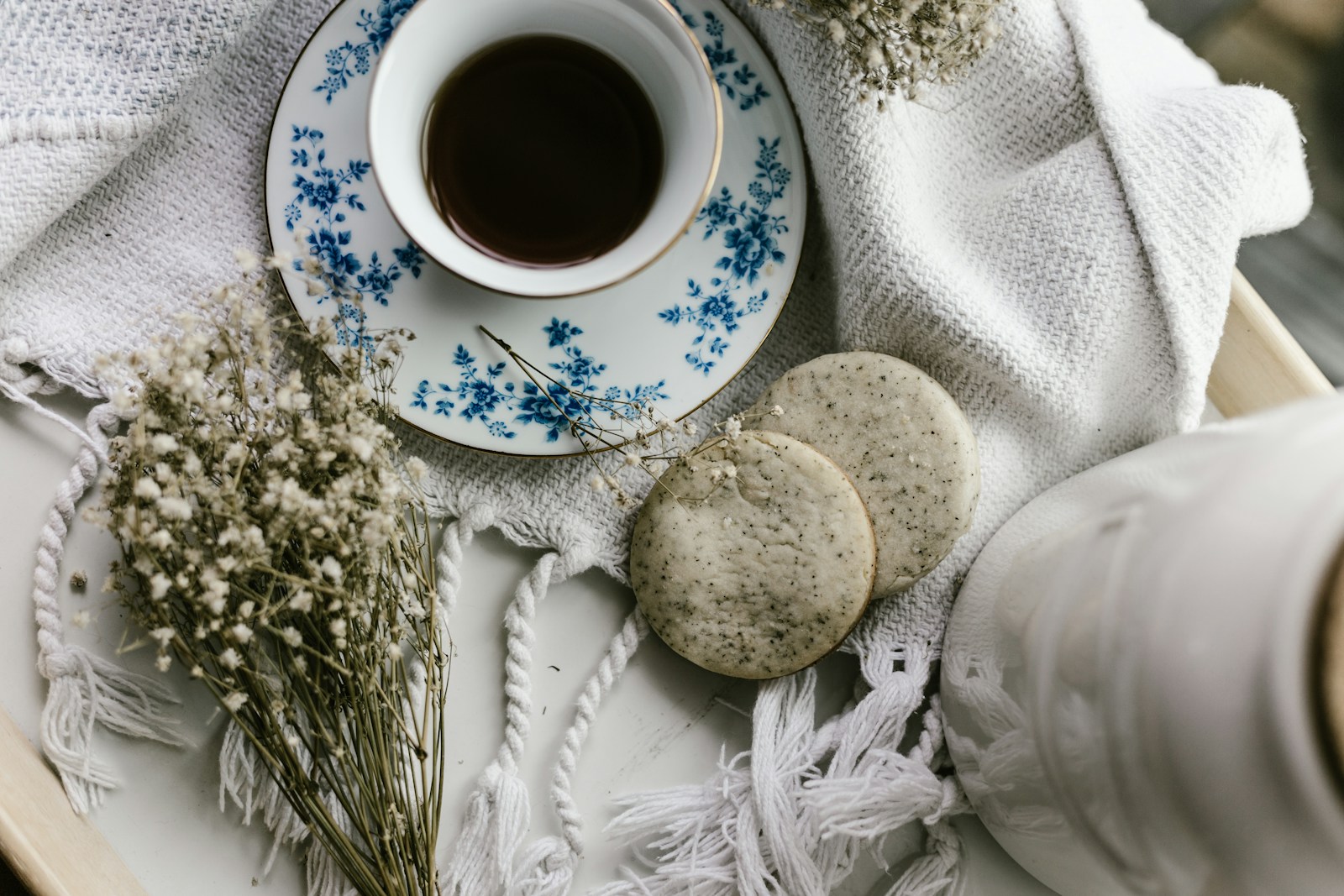 A cozy corner with a cup of coffee and biscuits on tray in golden sunlight